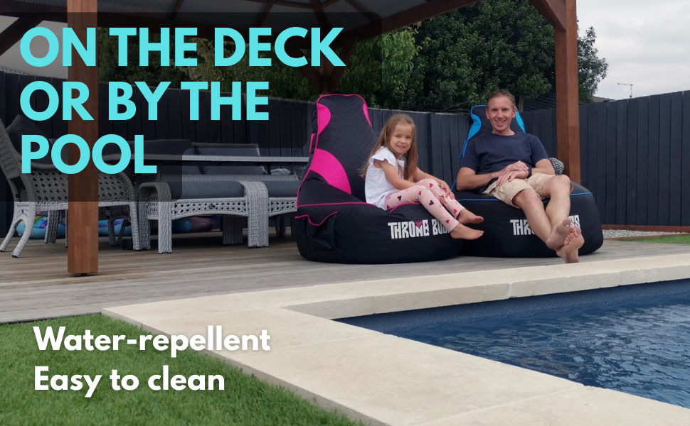 Father and daughter on gaming bean bags by the pool deck