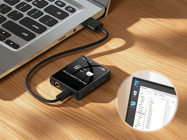 Black USB hub device with cable connected to laptop on wooden desk, displaying data transfer interface on smartphone screen.