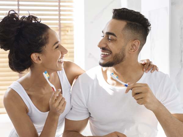 woman and man brushing teeth 