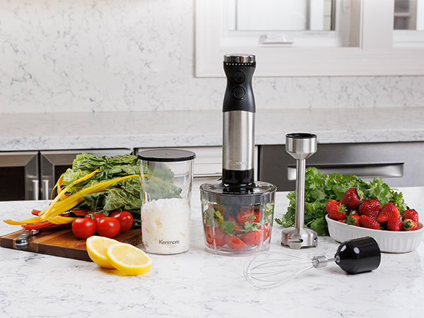 Kenmore hand blender and attachments with food on a marbled white kitchen counter