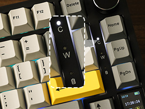 Close-up of computer keyboard keys, focusing on a black W key with surrounding white keys and one yellow key visible.