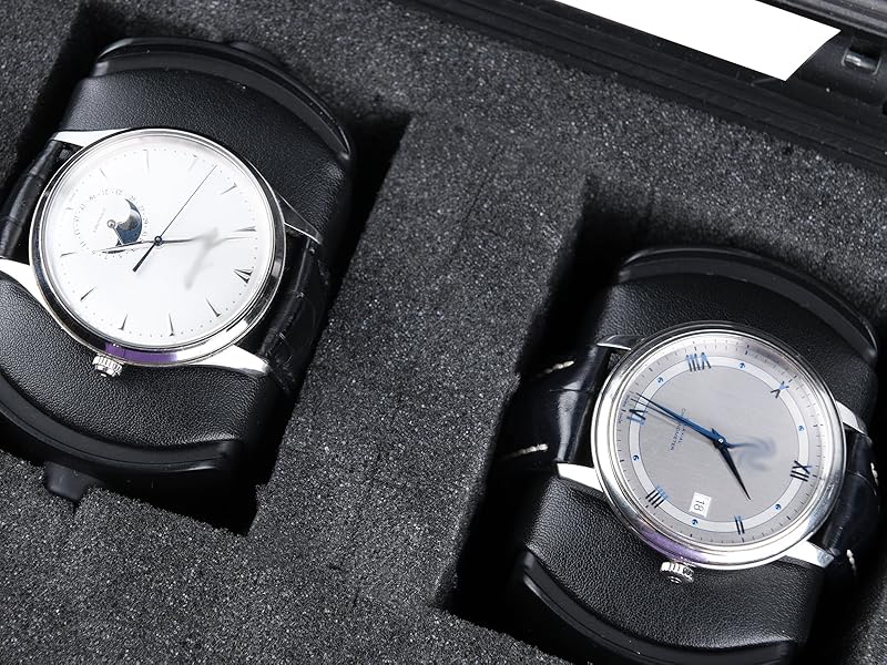 Two analog watches with silver cases and light-colored dials displayed in protective black foam cushioning.