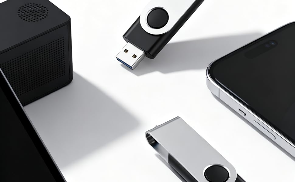 Black USB flash drives with swivel design shown against white background with laptop and device edges visible. Minimalist product photography setup with dramatic shadows.