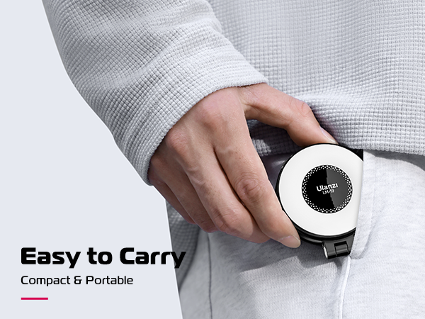 Hand holding small, circular white device with black center display. Text reads 'Easy to Carry, Compact &amp; Portable'. Device fits in pocket, demonstrating portability.