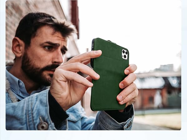 Green smartphone case being held by a person taking a photo. Case appears to have a textured or matte finish.