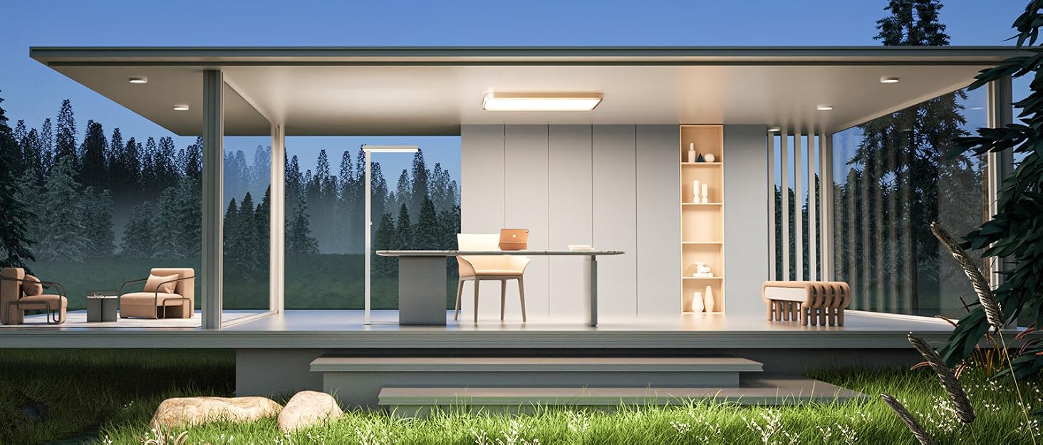 Modern, glass-walled prefab structure in a forest setting at dusk. Interior lighting illuminates minimalist furnishings and open-plan design.
