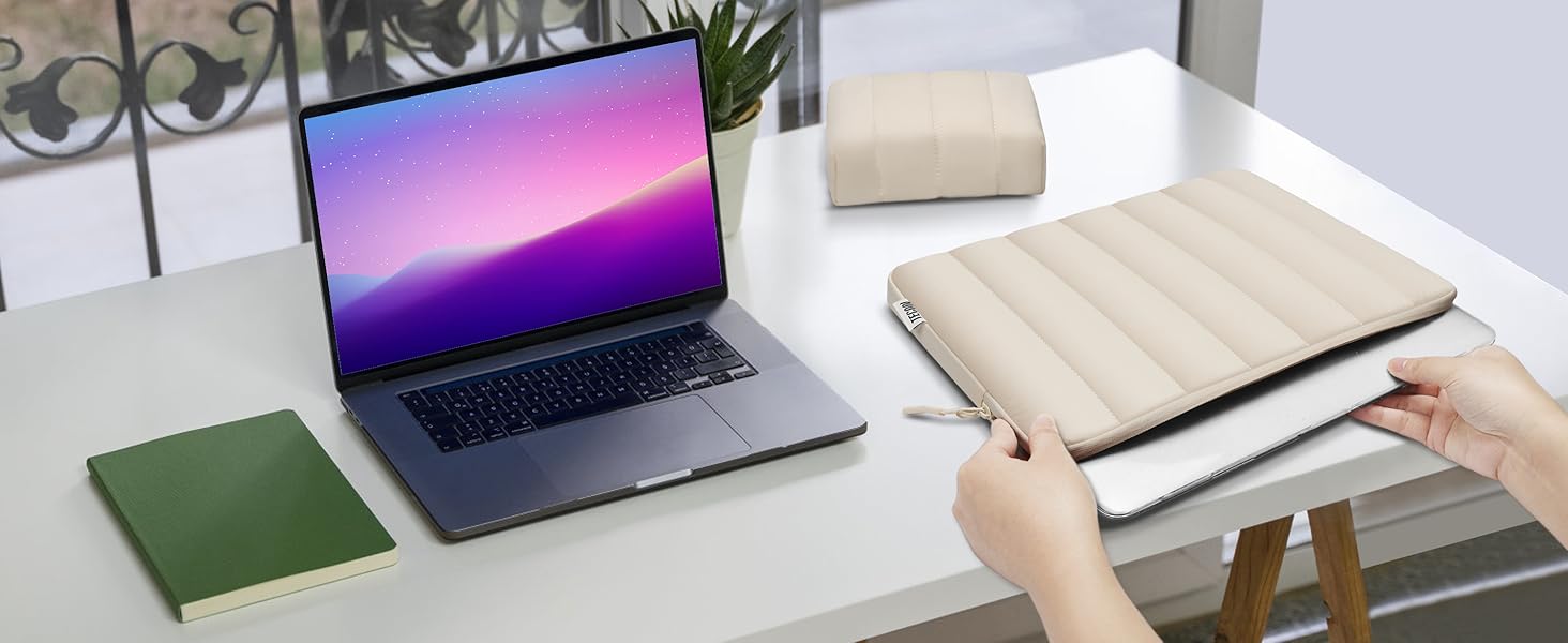 a person is sitting at a desk with a laptop and a notebook.