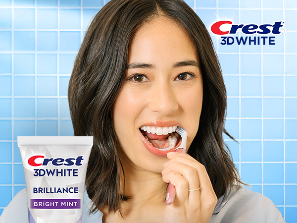 Happy woman brushing her teeth with Crest 3DWhite.