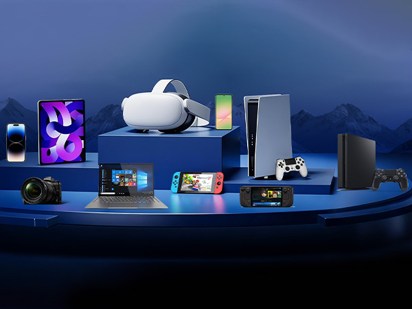 Collection of gaming and tech devices displayed on blue surface, including Meta Quest headset, PlayStation 5, Nintendo Switch, and various controllers and accessories.