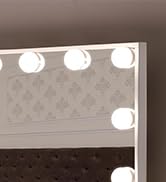 Partial view of a vanity mirror with round light bulbs along the top edge, suggesting a makeup or dressing room setup.