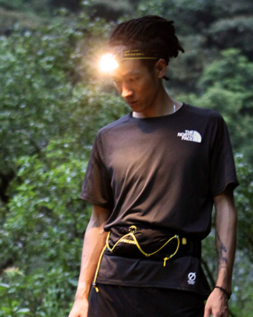 trail runner with his headlamp turned on