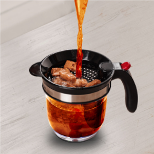 Liquid and food being poured into Fat Separator via top strainer.