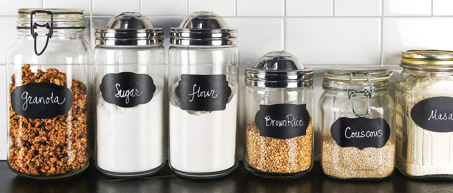 chalkboard labeled glass containers on countertop filled with assorted pantry products