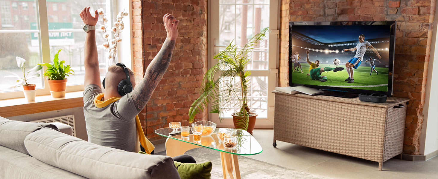 A man watches a wonderful football match with TV headphones