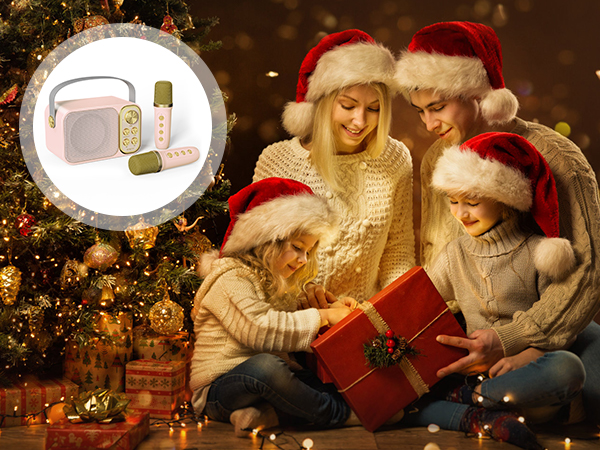 Group opening a large red gift box near a Christmas tree. Circular inset shows beauty products including a pink bag and green bottle.