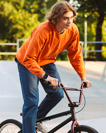 a young man riding a bike on a skateboard ramp.