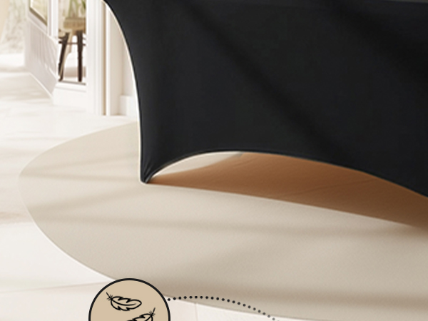 Black fabric or material draped over tan/beige wooden curved edge or furniture piece in minimalist interior setting with white walls and doorway.