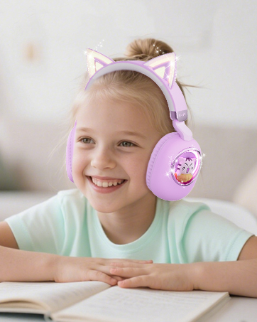 Young student wearing pink cat-ear themed headphones while studying or reading at a desk. Headphones feature cute animal design elements.